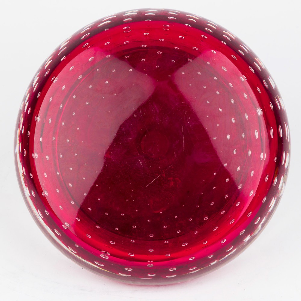 A circular ruby red glass inkwell featuring a controlled bubble pattern with a brass collar and matching glass stopper. View III