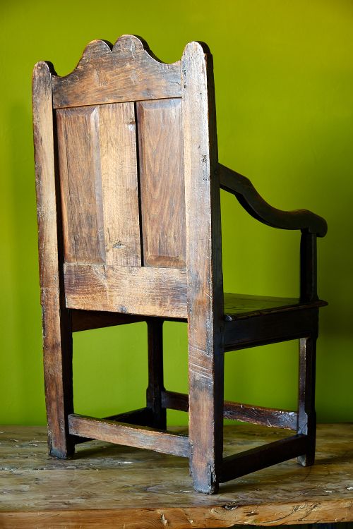 A late 17th-century dark oak armchair featuring a panelled backrest, shaped crest rail, curved armrests, rectangular wooden seat, and square legs with low stretchers. View IV