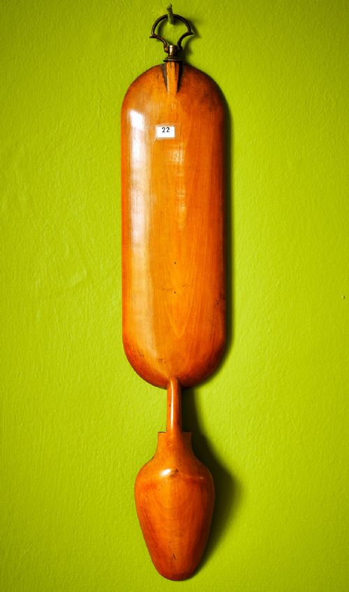 A carved wooden Welsh love spoon featuring polychrome wax inlay, glazed inset panels, incised initials AP, the date 1861, and a brass suspension loop at the top. View IV