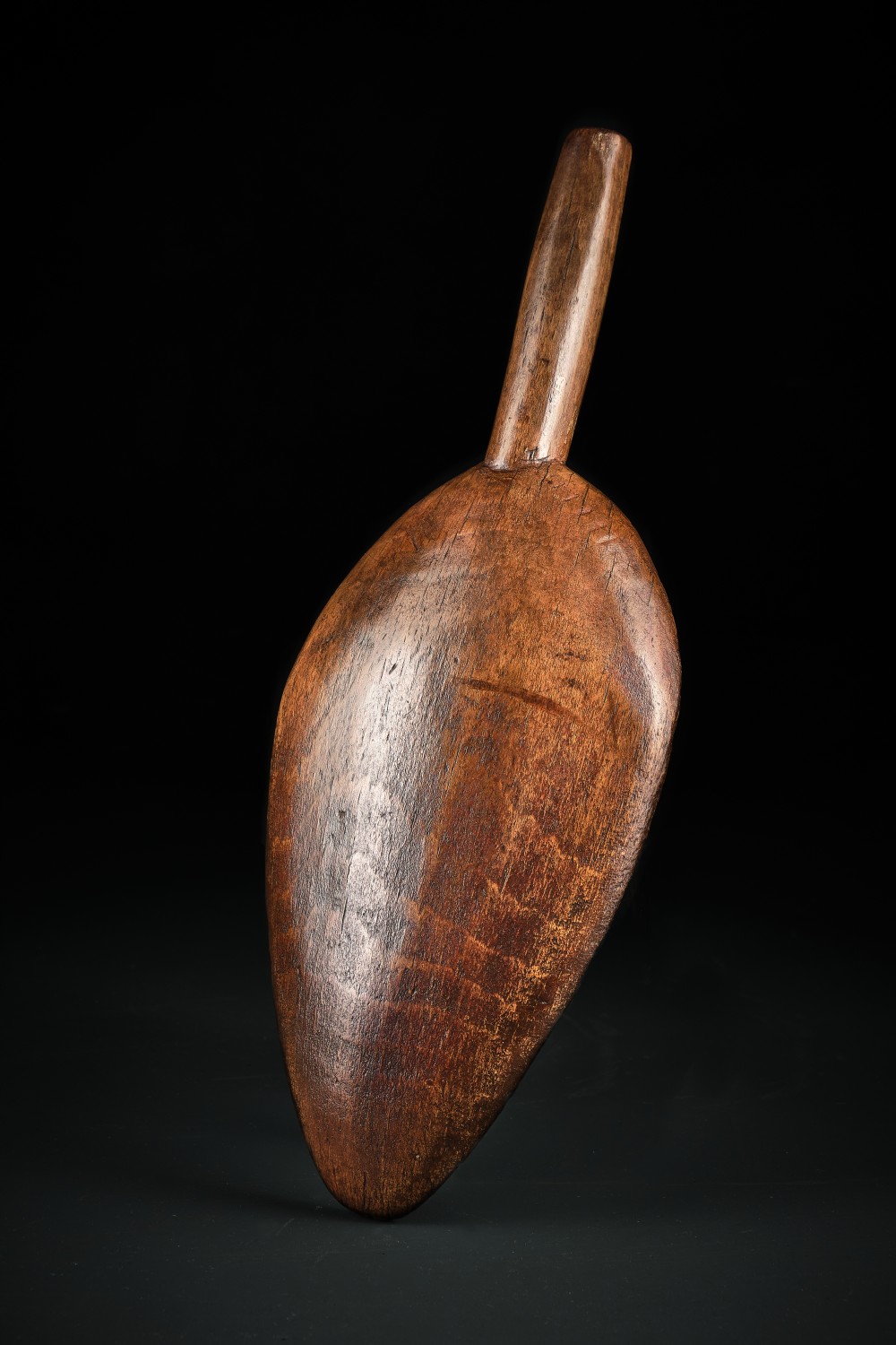 A hand-carved dark beechwood flour and grain scoop with a tapered cylindrical handle and rich patinated surface. View II