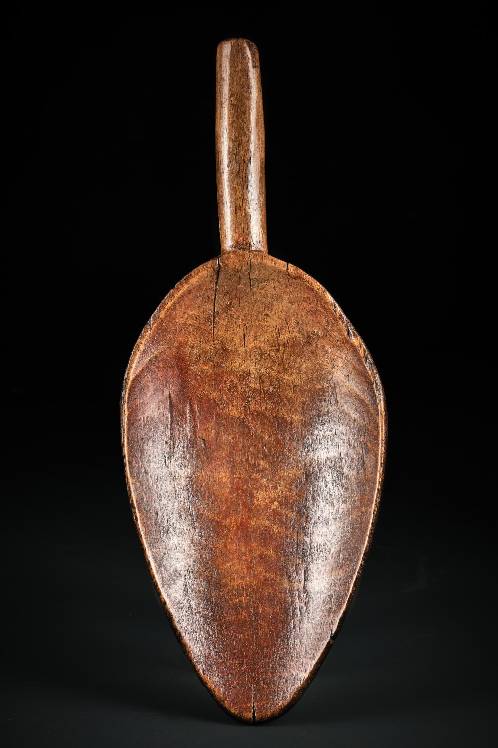A hand-carved dark beechwood flour and grain scoop with a tapered cylindrical handle and rich patinated surface. View III