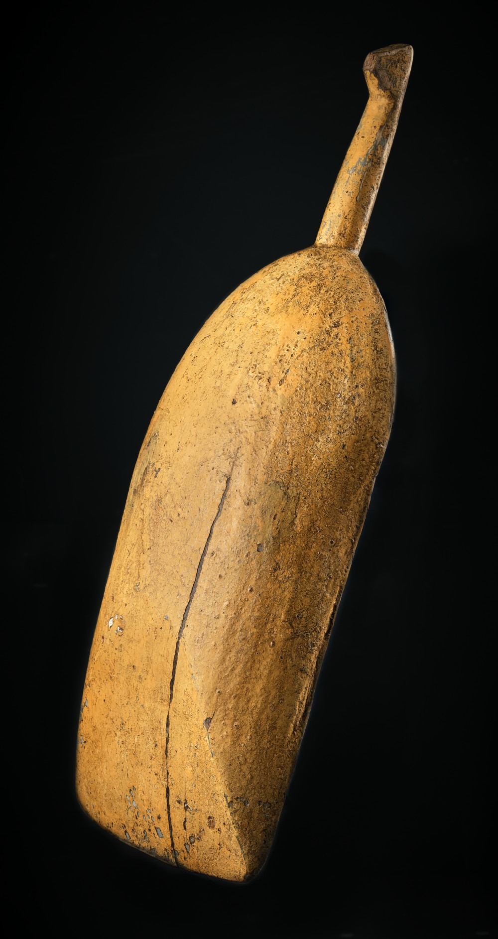 An antique carved wooden grain scoop featuring distressed yellow ochre paint and an integral shaped handle. View II