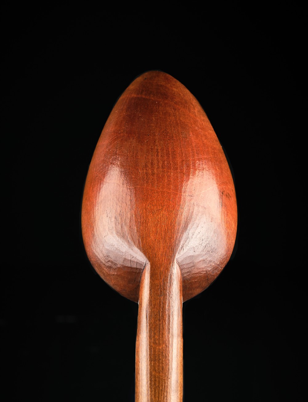 A long-handled Georgian beechwood basting spoon with a carved oval bowl against a black background. View IV