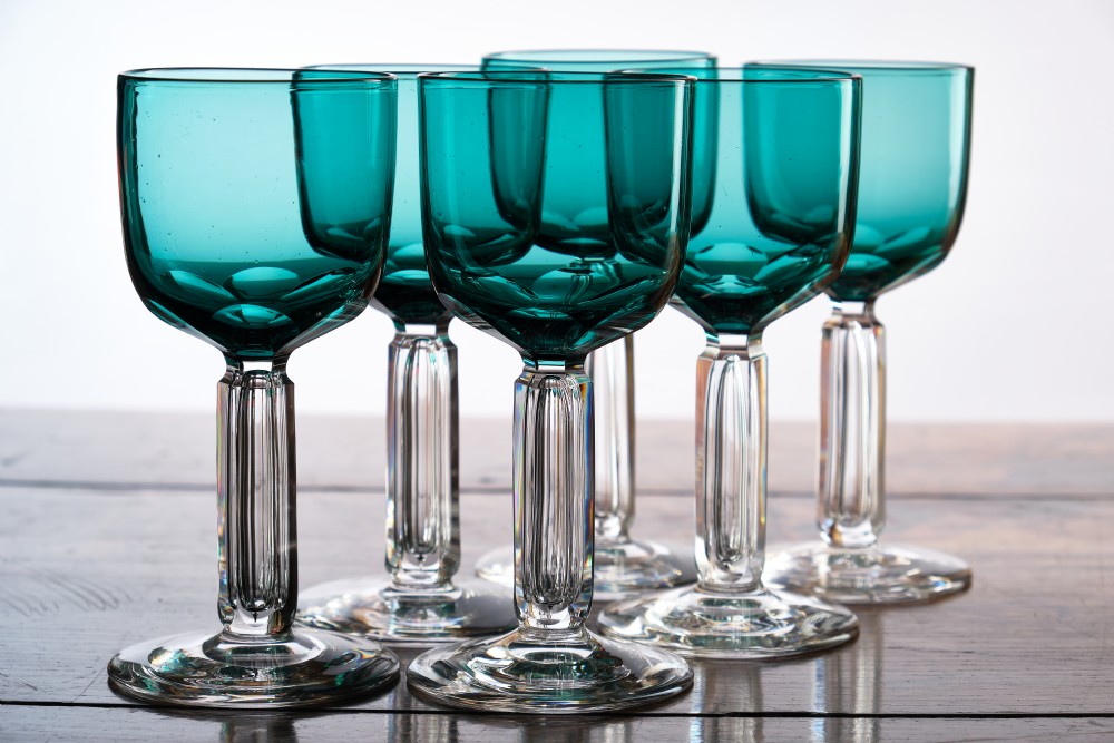 A Victorian teal glass stemware piece featuring a round coloured bowl and a clear faceted cut stem on a circular base. View II
