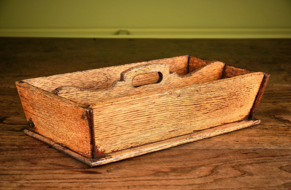 A rectangular Victorian oak cutlery box featuring two divided compartments and a raised central carrying handle.