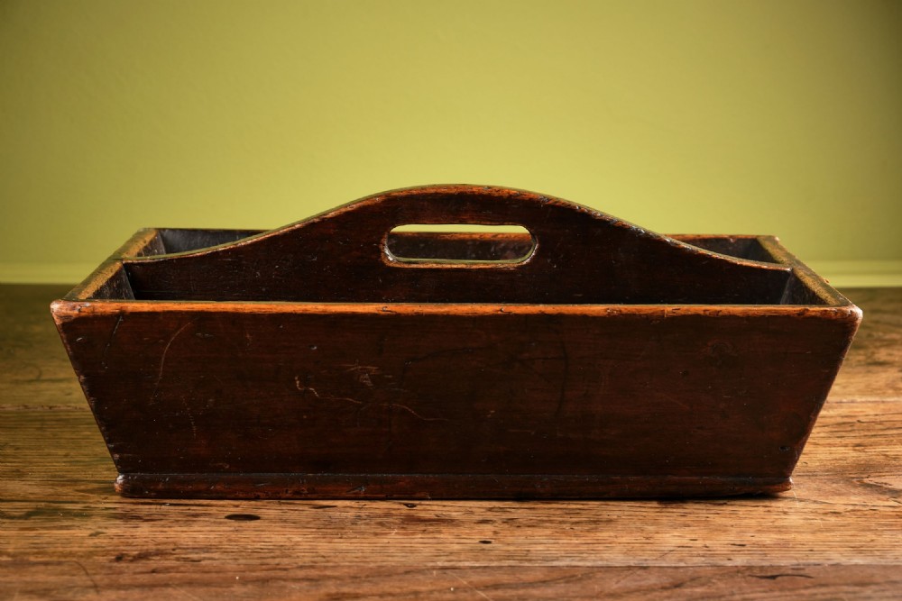 A dark brown antique pine cutlery tray featuring two open compartments separated by a central shaped divider with an integrated handle cut-out.