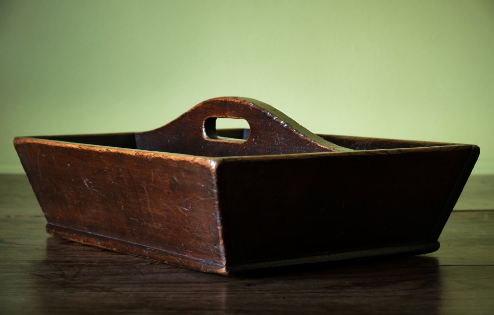 A dark brown antique pine cutlery tray featuring two open compartments separated by a central shaped divider with an integrated handle cut-out. View V