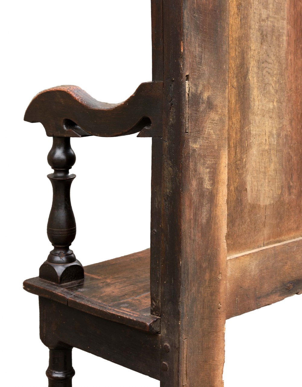 A high-backed dark oak settle with fielded panelling across the backrest, turned front legs, and a long wooden seat. View VII