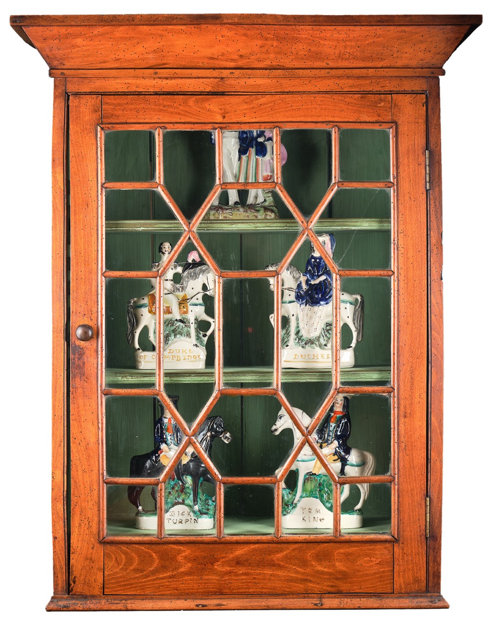 An antique timber wall cabinet featuring a geometric glazed glass door and a painted green interior with shelves. View II