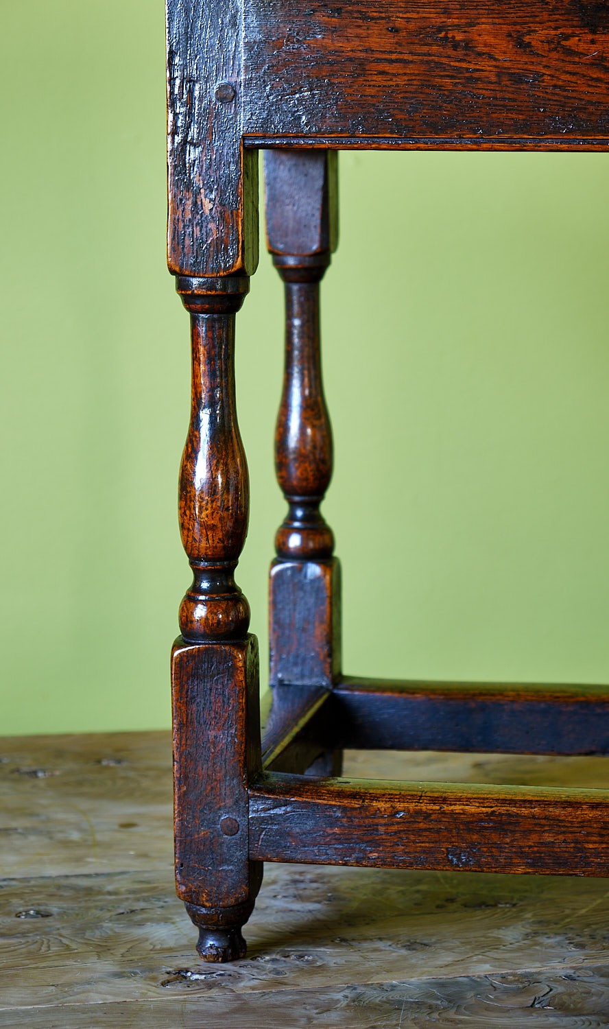A small early 18th-century dark oak and elm occasional table featuring turned legs, a plank top, and lower stretchers. View IV