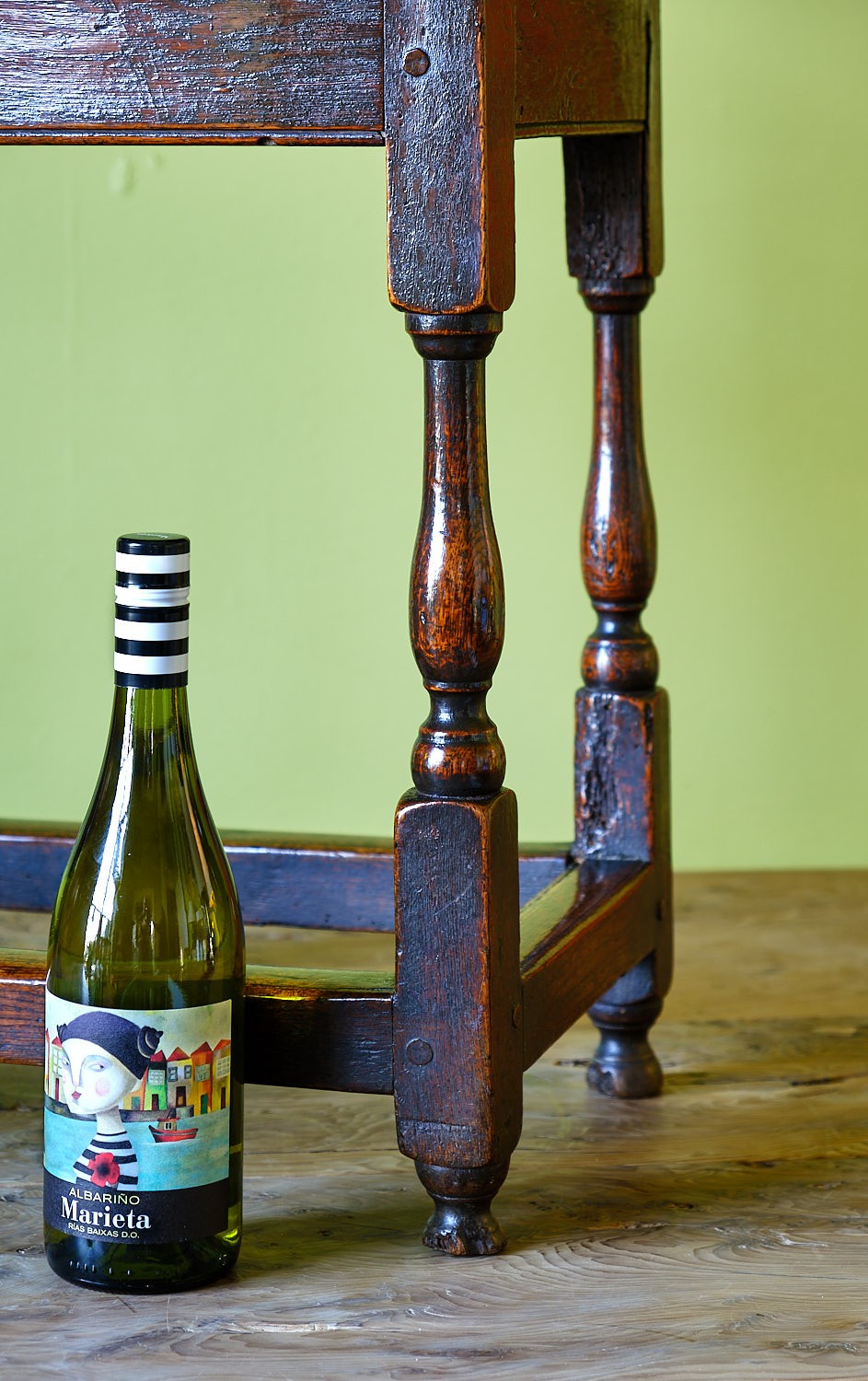 A small early 18th-century dark oak and elm occasional table featuring turned legs, a plank top, and lower stretchers. View V