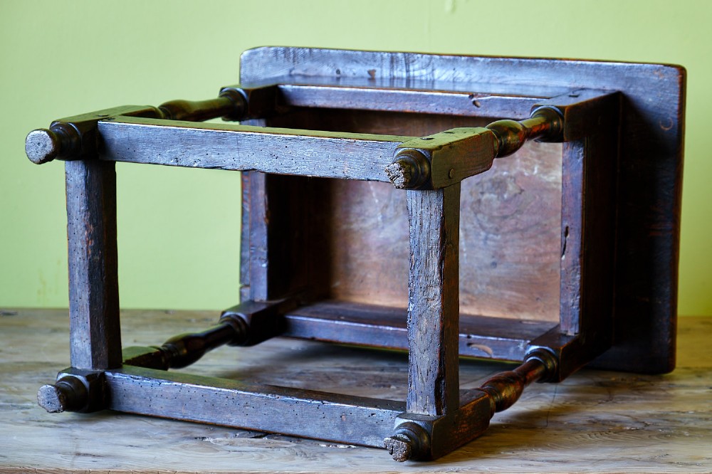 A small early 18th-century dark oak and elm occasional table featuring turned legs, a plank top, and lower stretchers. View VII