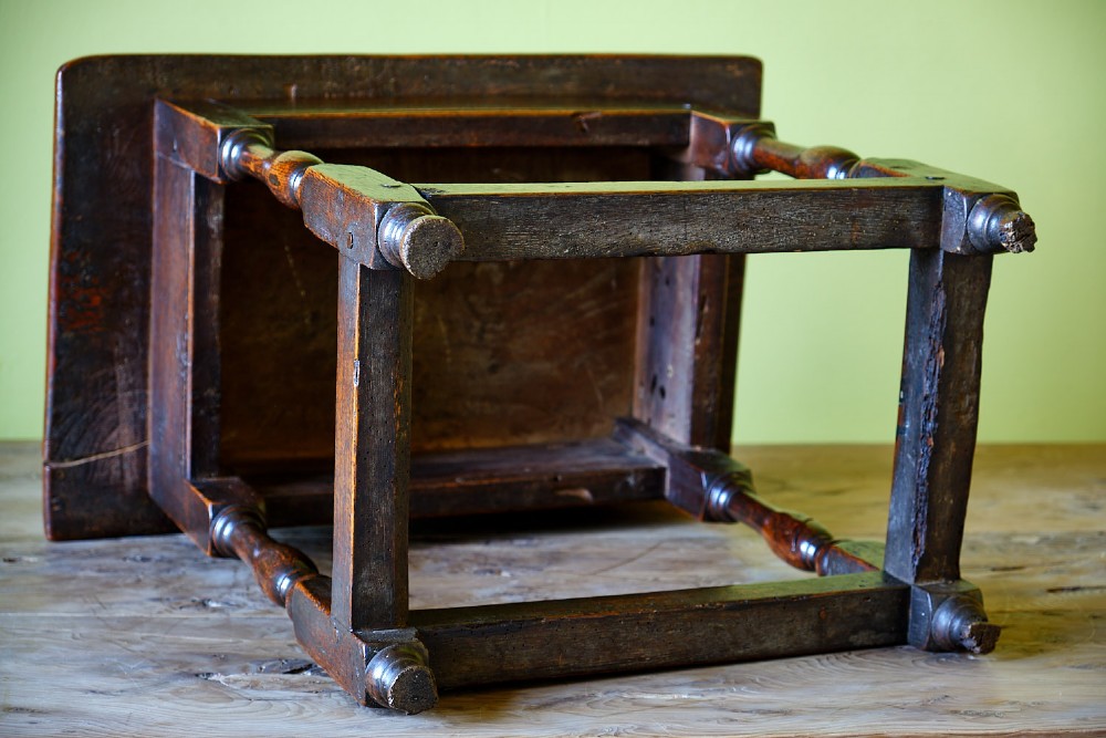 A small early 18th-century dark oak and elm occasional table featuring turned legs, a plank top, and lower stretchers. View VIII