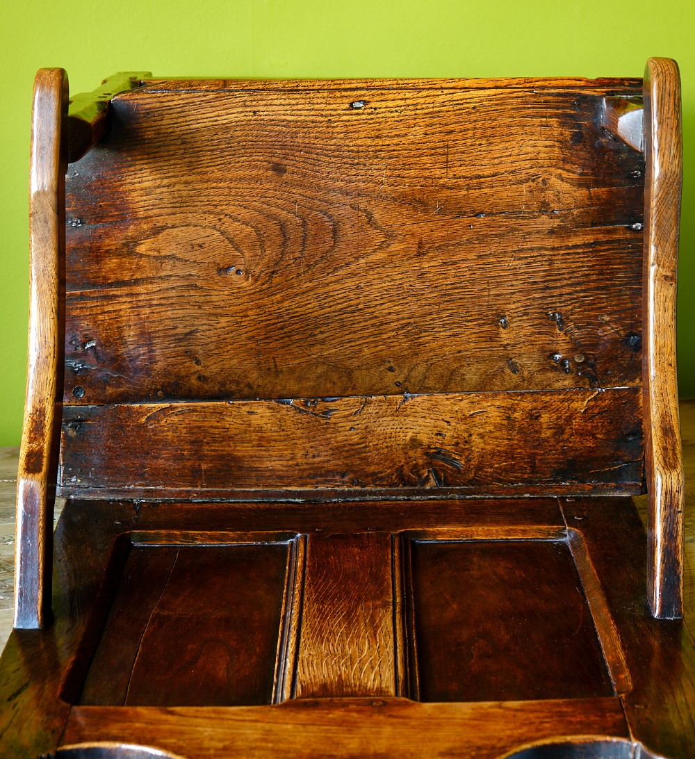 A late 17th-century dark oak armchair featuring a panelled backrest, shaped crest rail, curved armrests, rectangular wooden seat, and square legs with low stretchers. View VII