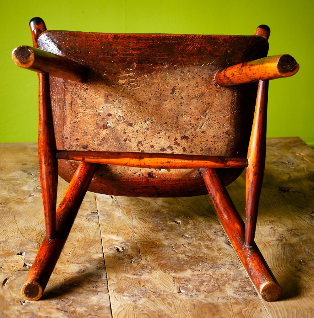 A primitive wooden Windsor armchair crafted from varied native hardwoods featuring a solid carved seat, shaped central back splat, tapered spindles, and splayed legs. View VIII