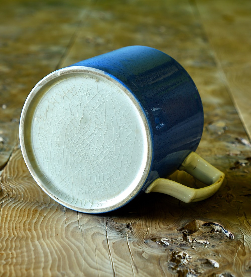 A large cylindrical ceramic mug featuring a speckled blue glazed exterior and a light cream interior with a matching handle. View III