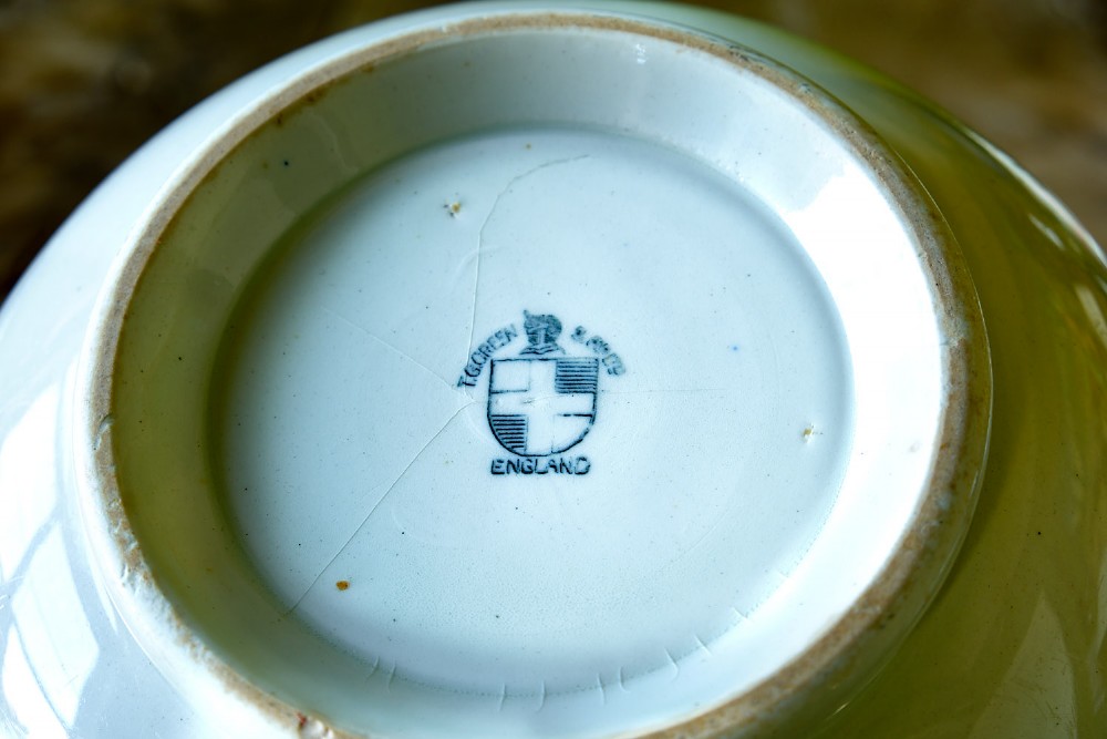 A white ceramic mixing bowl featuring a wide horizontal green band near the rim and three thin blue stripes around the lower body. View II