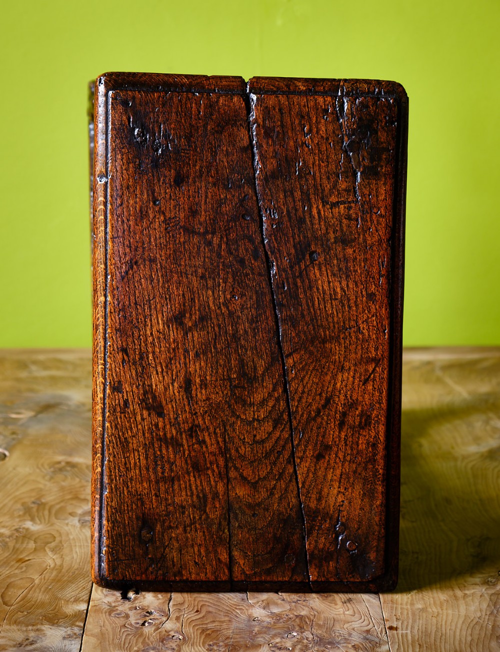 A dark oak seventeenth-century joined stool with a rectangular top, carved apron frieze, turned legs, and low box stretchers. View IV