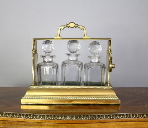 A Victorian Three Bottle Brass Tantalus Patented Bentjamann's, London.