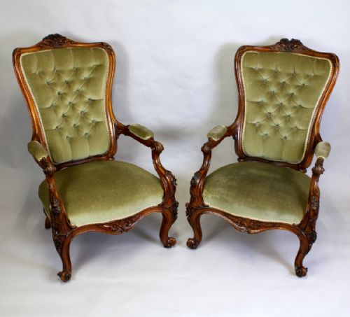 A Pair of Victorian Walnut Carved Open Arm Chairs