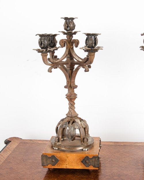 fig 1. A pair of five-branch Gothic Revival metal candelabra featuring foliate cups, twisted columns, and wooden bases with iron strapwork.