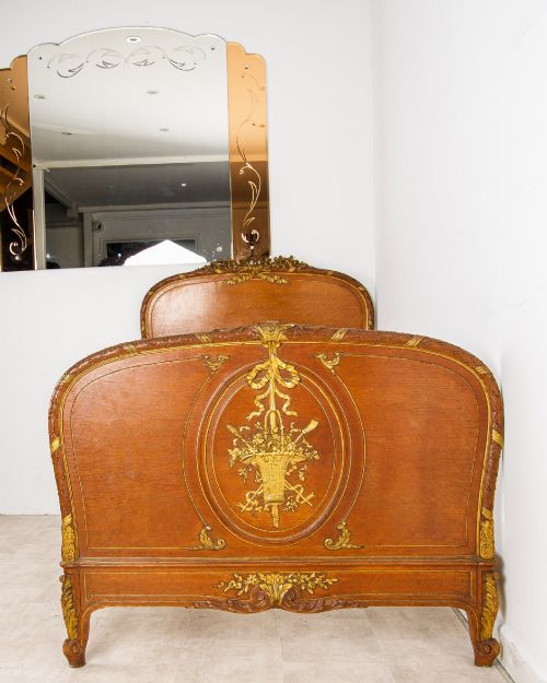 fig 1. An antique French Louis XV style daybed featuring polished walnut panels, giltwood rococo carvings, and brass side rails.