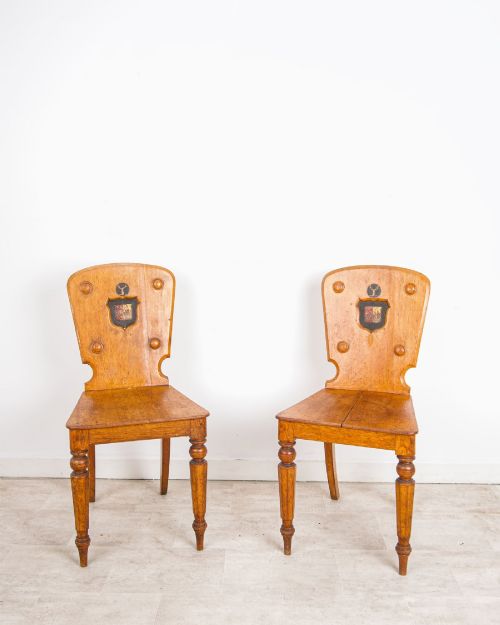 ANTIQUE PAIR OF OAK HALL CHAIRS WITH HERALDIC SHIELD BACKS