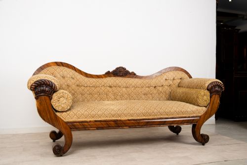 fig 2. A Victorian rosewood settee featuring carved scroll ends, a central carved cresting, and patterned mustard yellow upholstery with bolster cushions.
