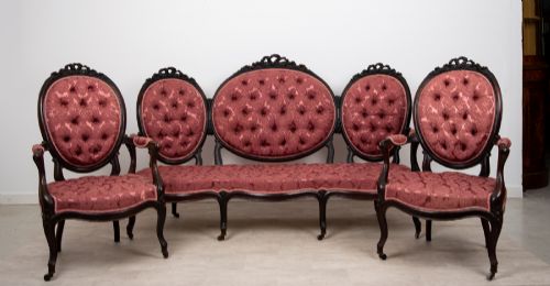 fig 1. A three-piece Victorian mahogany salon suite featuring a three-back settee and two matching armchairs upholstered in rose-pink deep-buttoned fabric.