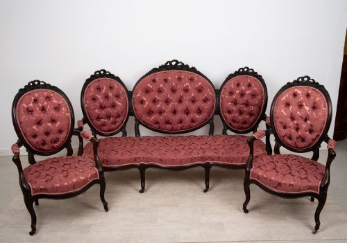 fig 2. A three-piece Victorian mahogany salon suite featuring a three-back settee and two matching armchairs upholstered in rose-pink deep-buttoned fabric.