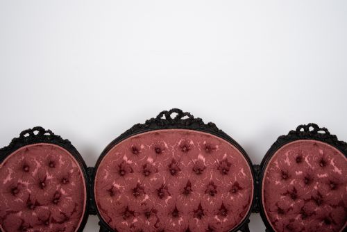 fig 5. A three-piece Victorian mahogany salon suite featuring a three-back settee and two matching armchairs upholstered in rose-pink deep-buttoned fabric.
