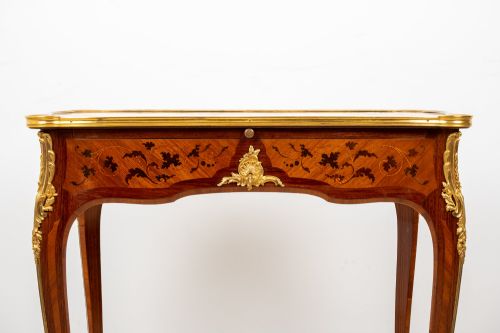 fig 3. A French Louis XV style kingwood bureau plat featuring floral marquetry inlay, curved cabriole legs, and gilt-bronze mounts.