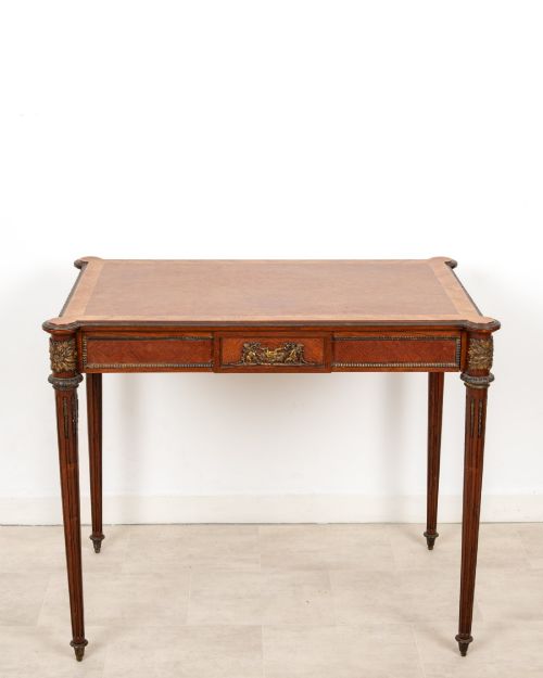 fig 1. An antique French kingwood writing table featuring geometric parquetry, a single central drawer with ormolu mounts, and four tapered fluted legs.
