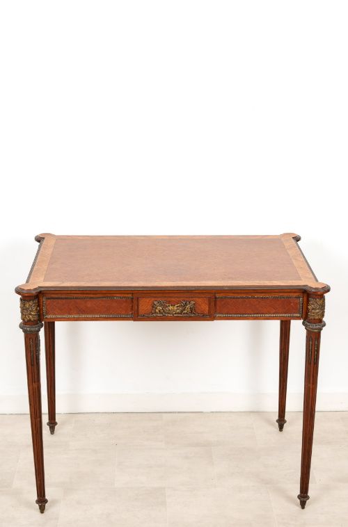 fig 2. An antique French kingwood writing table featuring geometric parquetry, a single central drawer with ormolu mounts, and four tapered fluted legs.