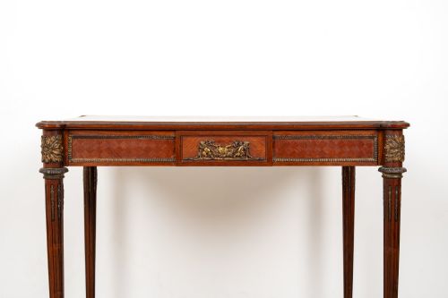 fig 3. An antique French kingwood writing table featuring geometric parquetry, a single central drawer with ormolu mounts, and four tapered fluted legs.