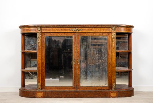 fig 1. A Victorian burr walnut credenza featuring central mirrored doors, open curved side shelves, and detailed gilt ormolu mounts.