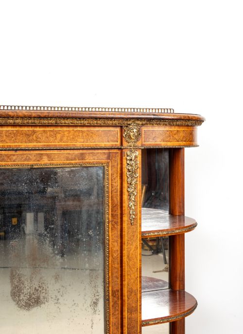 fig 2. A Victorian burr walnut credenza featuring central mirrored doors, open curved side shelves, and detailed gilt ormolu mounts.
