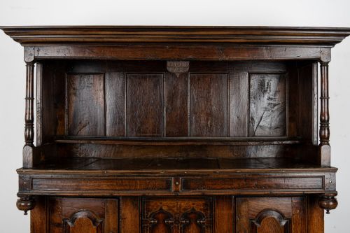 fig 4. An 18th-century dark Welsh oak cwpwrdd tridarn three-tier press cupboard featuring fielded panels and turned canopy posts.