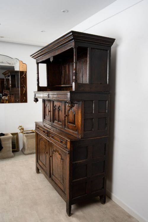 fig 5. An 18th-century dark Welsh oak cwpwrdd tridarn three-tier press cupboard featuring fielded panels and turned canopy posts.