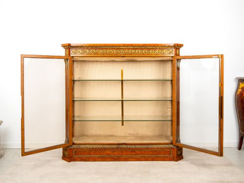 fig 9. A large veneered display cabinet featuring gilt-bronze mounts, glazed twin doors, glass shelving, and a fabric-lined interior.