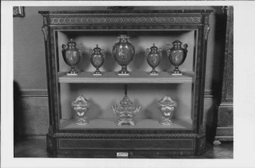 A large veneered display cabinet featuring gilt-bronze mounts, glazed twin doors, glass shelving, and a fabric-lined interior. View XIII