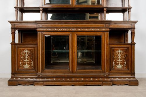 fig 3. A large late Victorian rosewood display cabinet featuring intricate inlay work, glazed upper and lower doors, an arched pediment, and mirrored back panels.