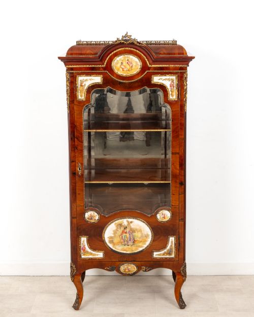 fig 1. An antique French walnut vitrine featuring a single glass door, hand-painted porcelain plaques, gilt-bronze ormolu mounts, and cabriole legs.