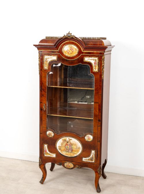 fig 2. An antique French walnut vitrine featuring a single glass door, hand-painted porcelain plaques, gilt-bronze ormolu mounts, and cabriole legs.