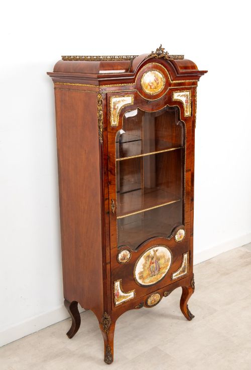 fig 3. An antique French walnut vitrine featuring a single glass door, hand-painted porcelain plaques, gilt-bronze ormolu mounts, and cabriole legs.