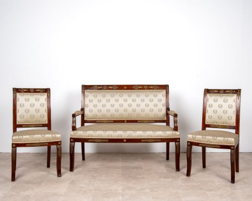fig 1. A three-piece antique French Empire Revival salon suite comprising a mahogany two-seater settee and two matching side chairs with gold silk laurel wreath upholstery and ormolu mounts.