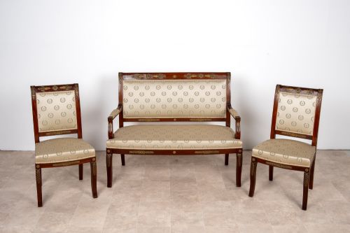 fig 2. A three-piece antique French Empire Revival salon suite comprising a mahogany two-seater settee and two matching side chairs with gold silk laurel wreath upholstery and ormolu mounts.