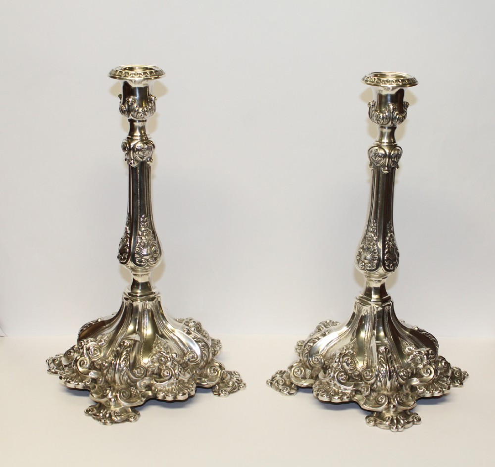 A PAIR OF REPOUSSE ROCOCO SILVER CANDLE STICKS