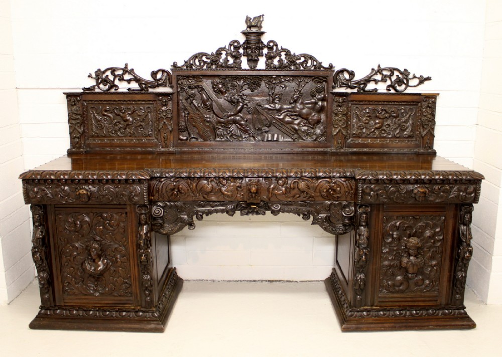 A LARGE CARVED OAK PEDESTAL SIDEBOARD IN THE BAROQUE TASTE