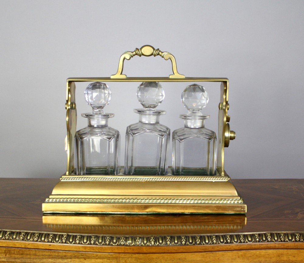 A Victorian Three Bottle Brass Tantalus Patented Bentjamann's, London.